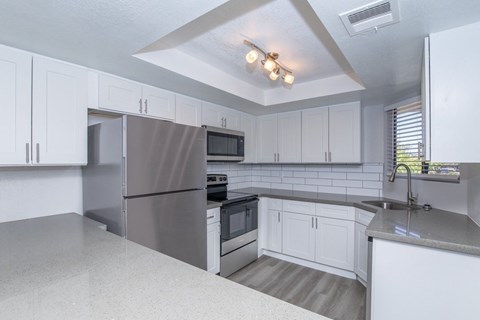 A kitchen with white cabinets and stainless steel appliances.