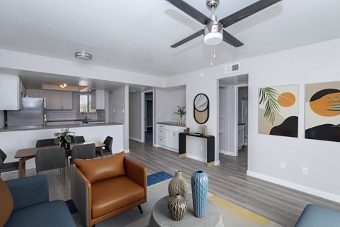 A living room with a brown leather chair and a grey coffee table with a blue vase on it.