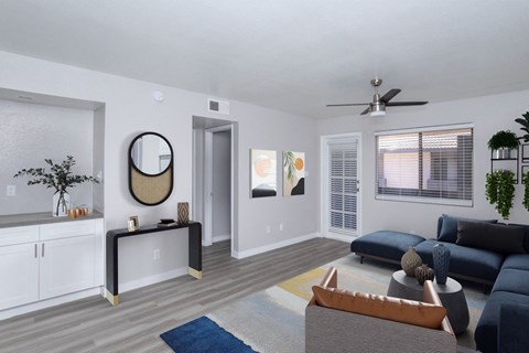 A living room with a blue couch and a wooden coffee table.