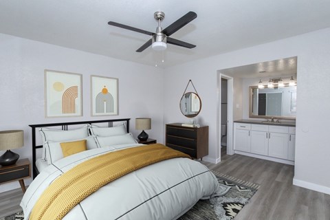 A bedroom with a bed, nightstand, and a ceiling fan.