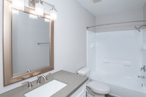 A bathroom with a sink, toilet, and bathtub.