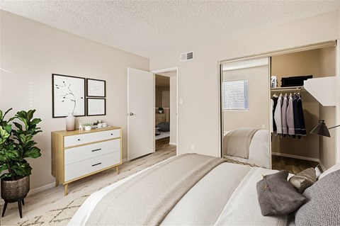 A bedroom with a bed, a dresser, and a wardrobe.