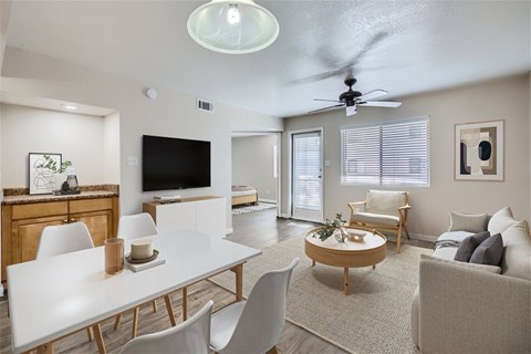 A modern living room with a white dining table and white chairs.