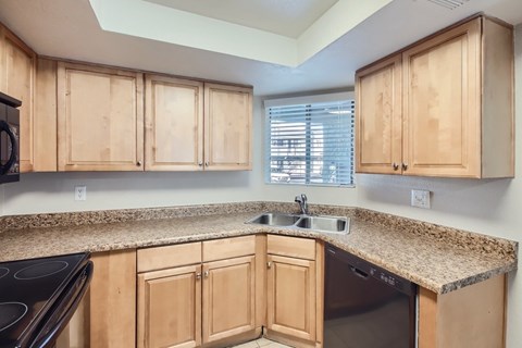 A kitchen with wooden cabinets and granite countertops.