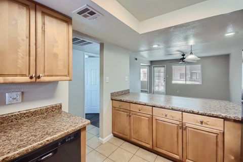 A kitchen with granite countertops and wooden cabinets.