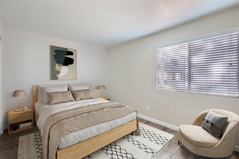 A bedroom with a large bed, a chair, and a painting on the wall.