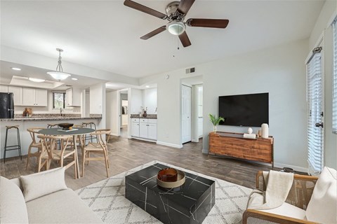 A modern living room with a black coffee table in the center.