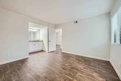 A room with wooden flooring and white walls.