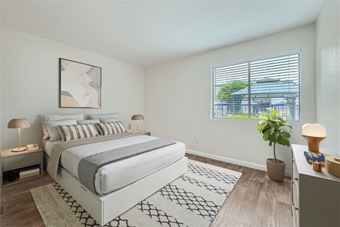 A bedroom with a large bed and a window overlooking a building.