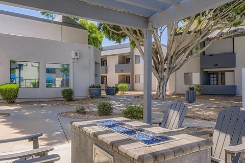 A patio with a table and chairs under a white pergola.