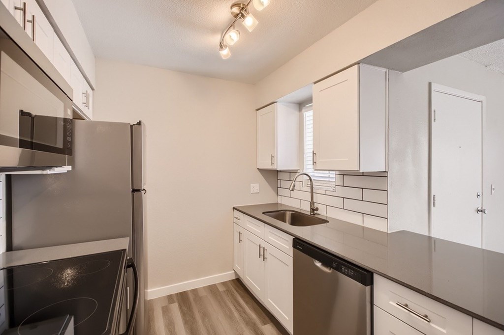 A kitchen with white cabinets and a black stove top oven.