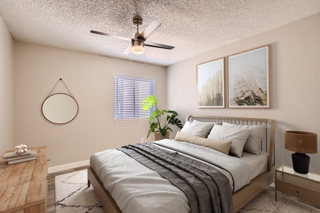 A bedroom with a bed, nightstand, and a ceiling fan.