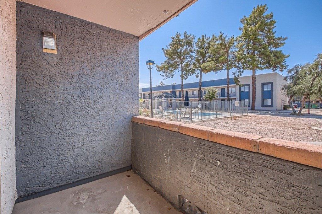 A concrete wall with a small window and a view of a construction site.