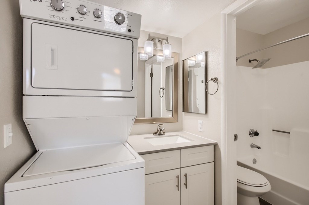 A white oven and sink in a small bathroom.