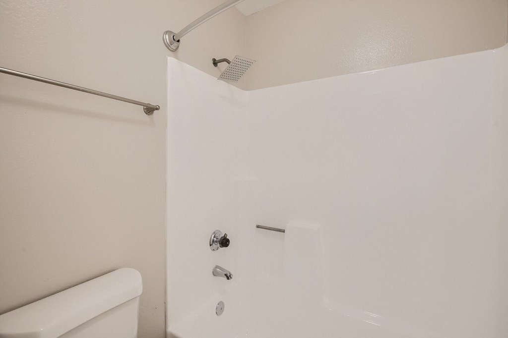 A white bathroom with a shower and a bathtub.