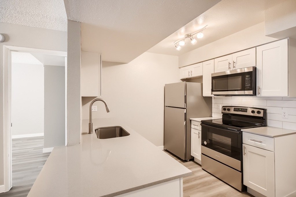 A kitchen with white cabinets and stainless steel appliances.
