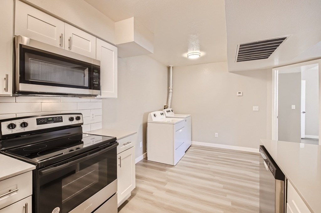 A kitchen with a black stove and white cabinets.