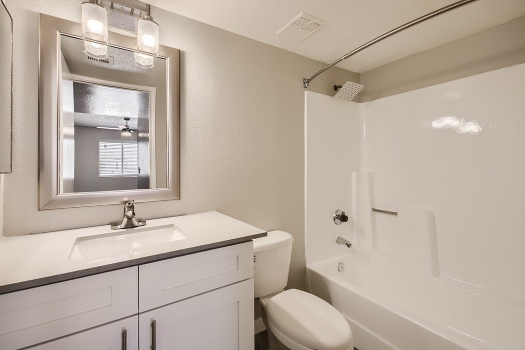 A white bathroom with a sink, toilet, and bathtub.