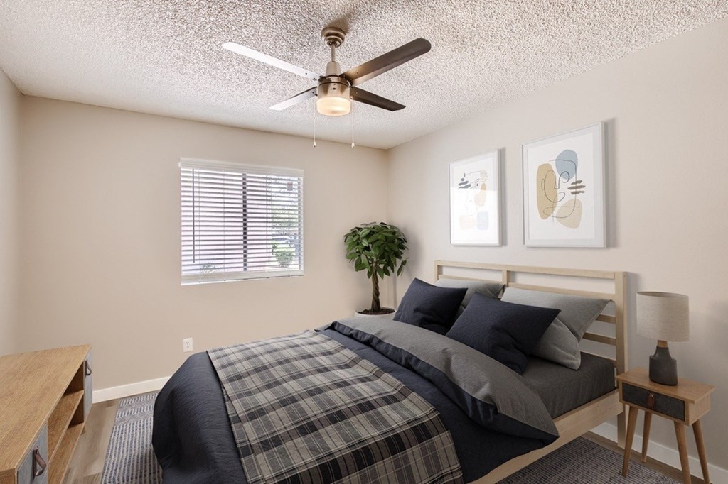 A bedroom with a bed, a ceiling fan, and a window with blinds.