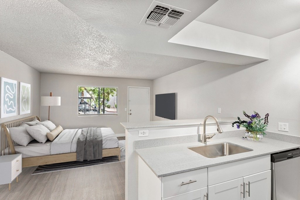 A modern kitchen with a bedroom area in the same room.