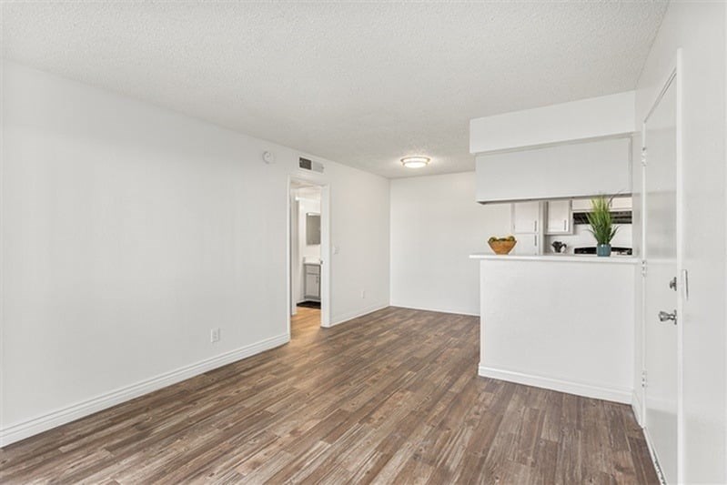 A room with wooden flooring and white walls.