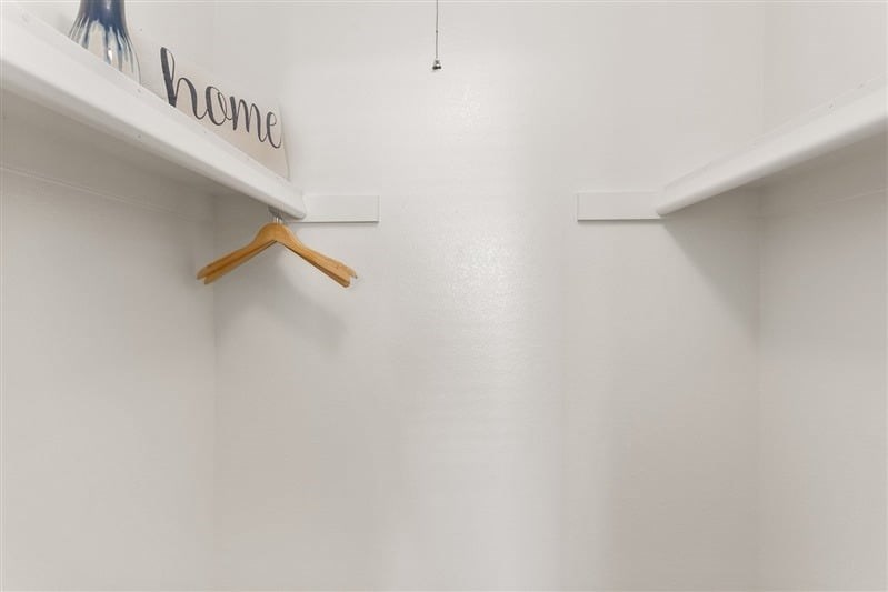 A white wall with a hanger and a sign that says home.