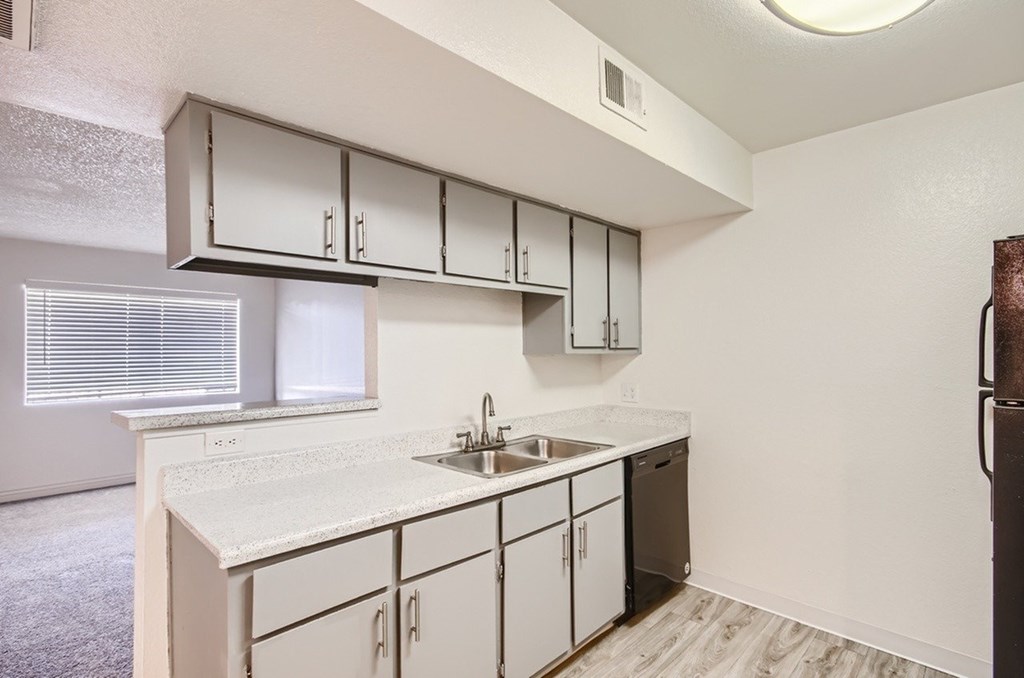 A kitchen with white cabinets and a sink.