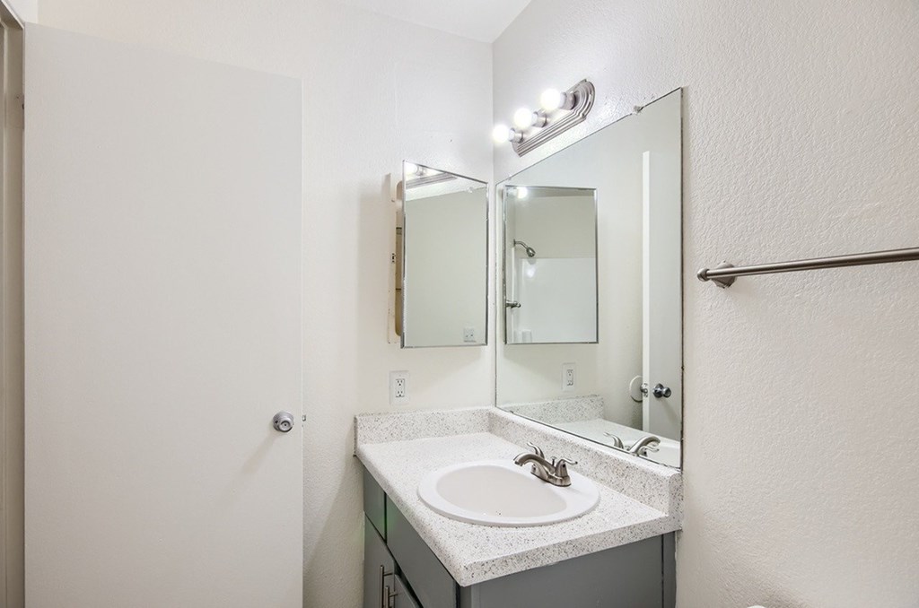 A bathroom with a sink and mirror.