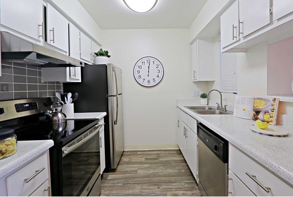 A kitchen with black appliances and white cabinets.