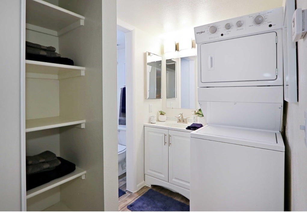 A small white kitchen with a sink and a refrigerator.