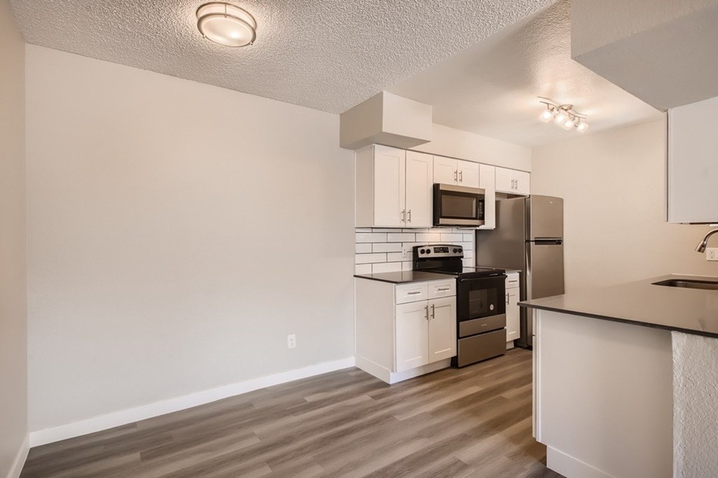 A kitchen with white cabinets and a microwave above the stove.