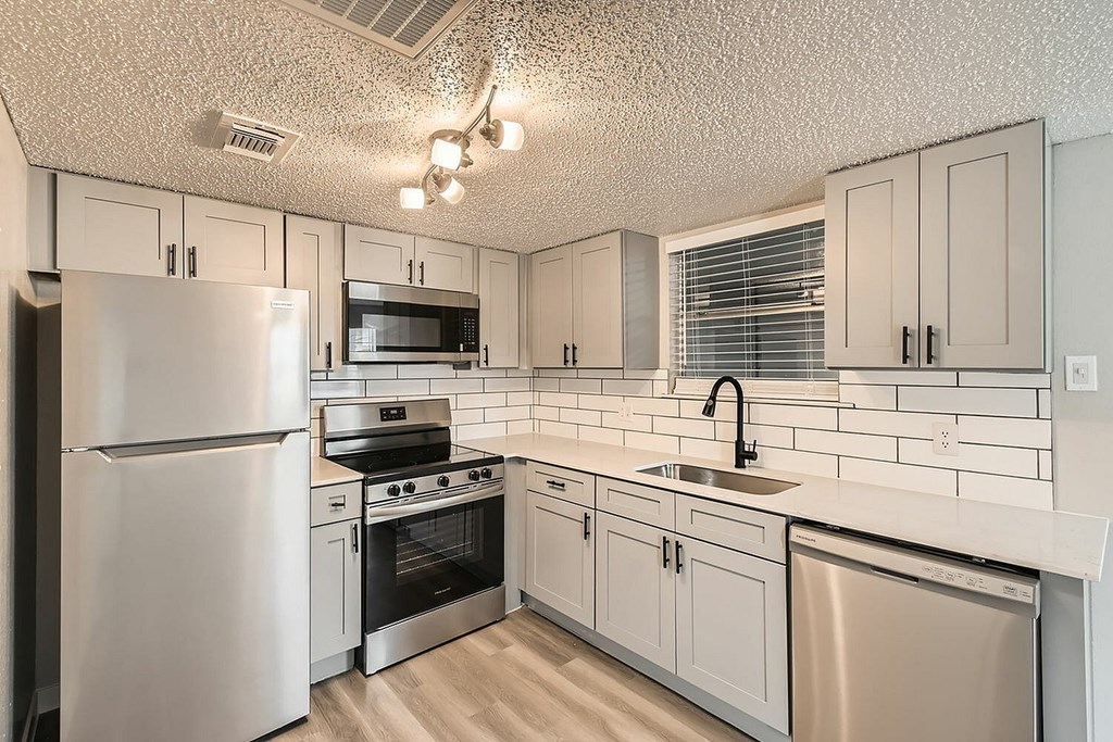 A kitchen with white appliances and cabinets.
