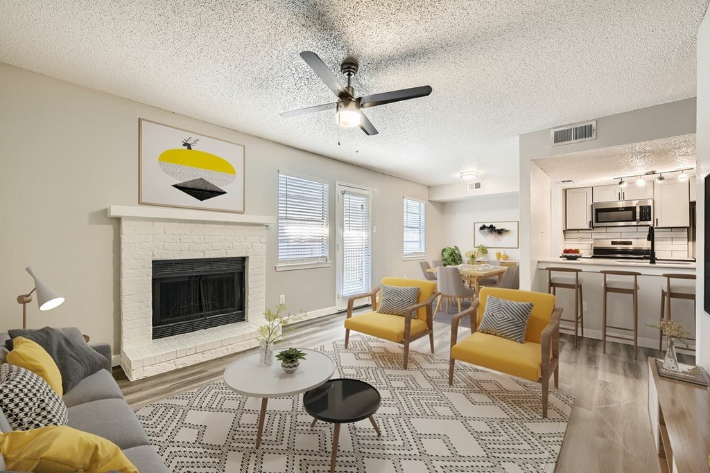 A living room with a fireplace and a ceiling fan.