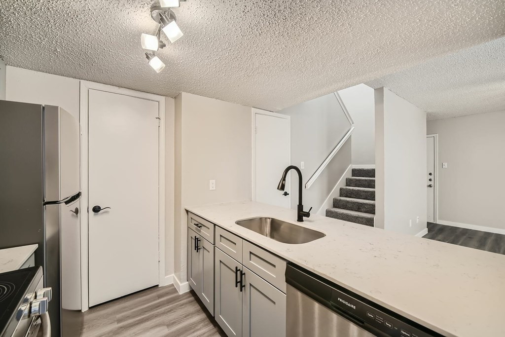A kitchen with a stainless steel dishwasher and a sink.