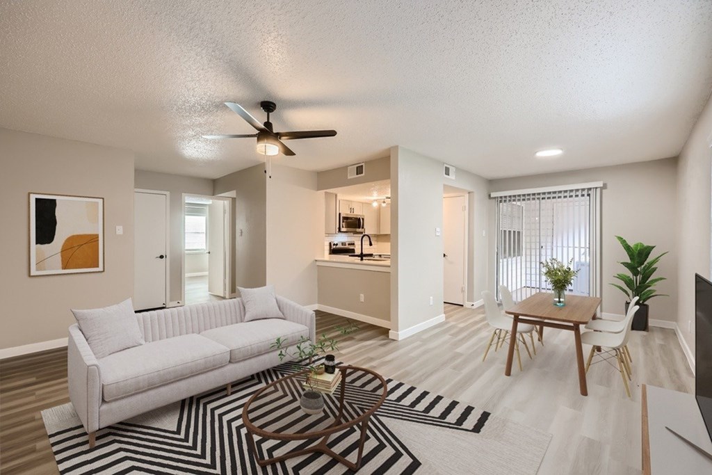 A living room with a white couch and a striped rug.
