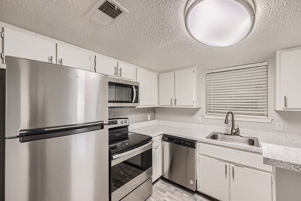 A kitchen with white cabinets and stainless steel appliances.