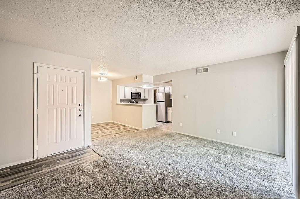 A white door is open to a room with a carpeted floor.