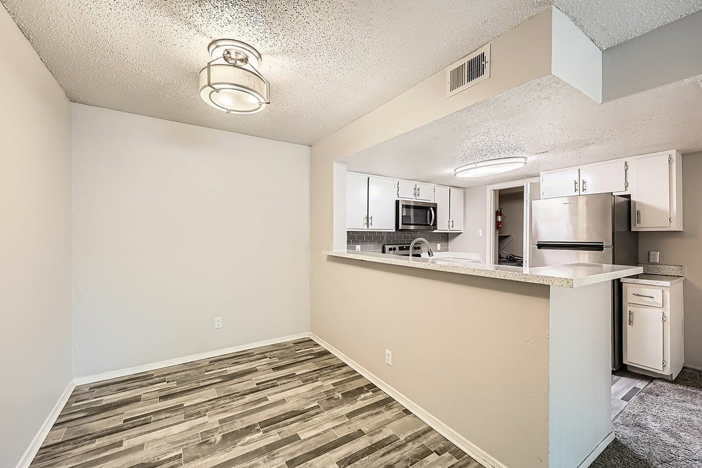 A kitchen area with a counter and a refrigerator.
