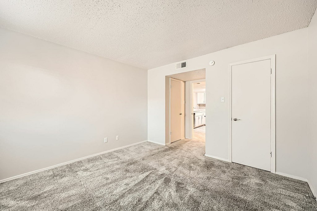 A room with a carpeted floor and white walls.