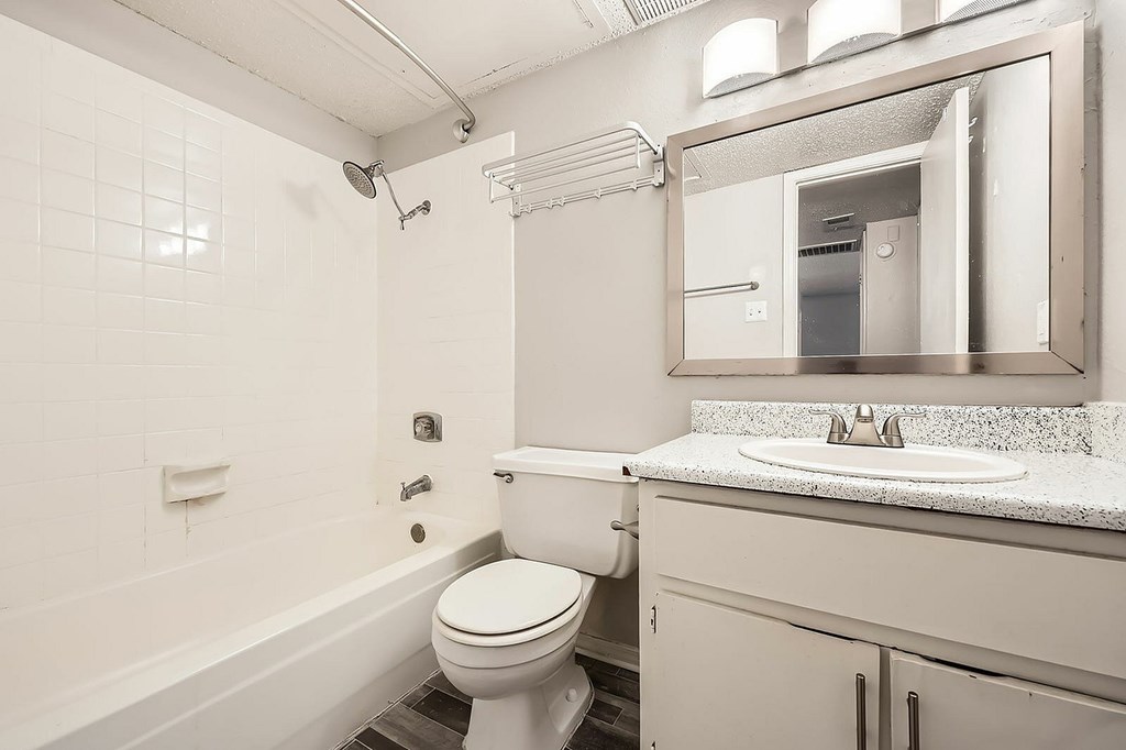 A white toilet sits in a bathroom next to a sink.