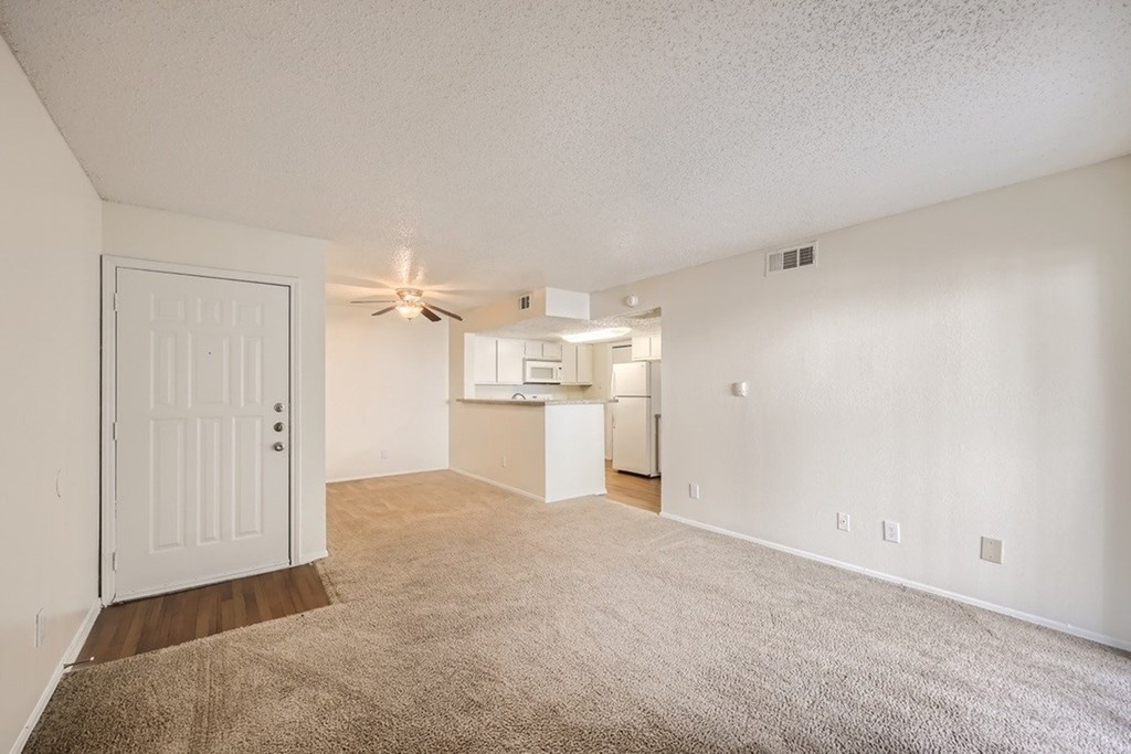 A room with a white door and a ceiling fan.