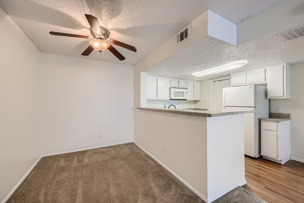 A kitchen area with a fan and a countertop.