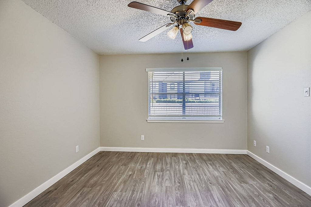 A white bathroom with a toilet, sink, mirror, and lights.