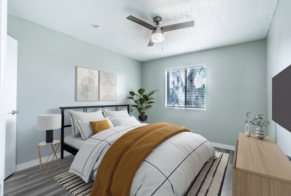 A bedroom with a bed, nightstand, and a ceiling fan.