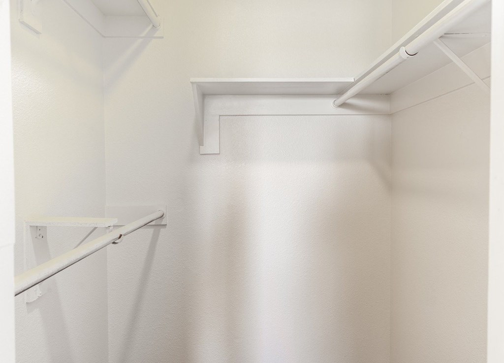 A white kitchen cabinet with a white shelf and white piping.