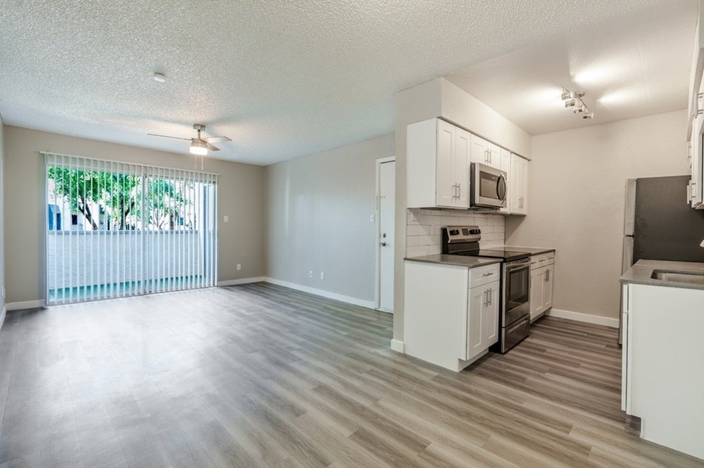 A spacious kitchen with white cabinets and appliances.