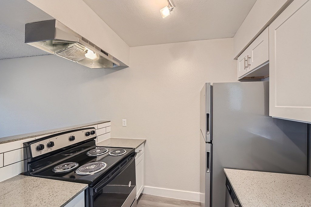 A kitchen with a stove, microwave, and refrigerator.