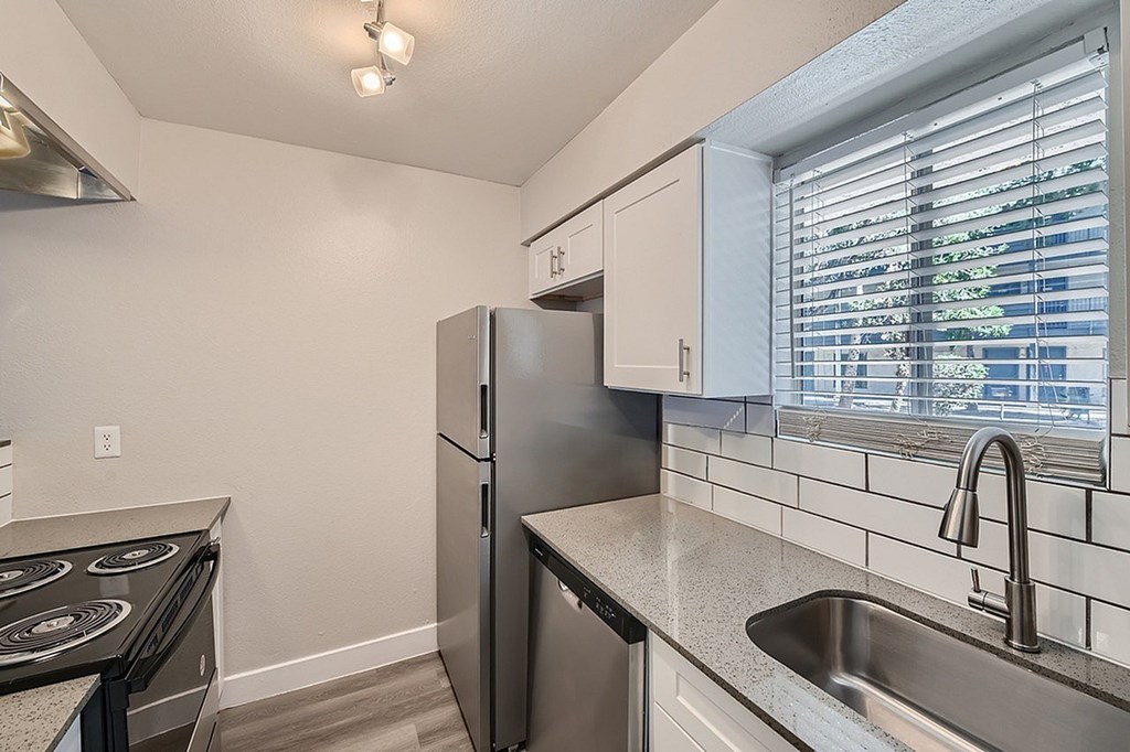 A kitchen with a stove, microwave, and refrigerator.
