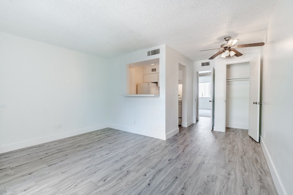 A room with a ceiling fan and a wall with a cutout.