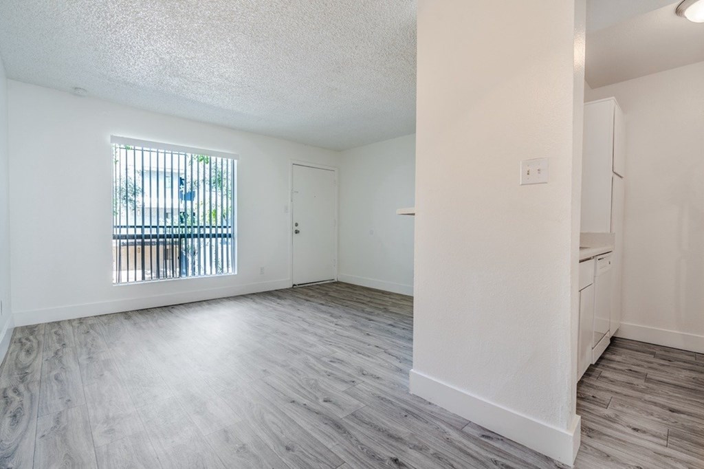 A room with a window and wooden flooring.